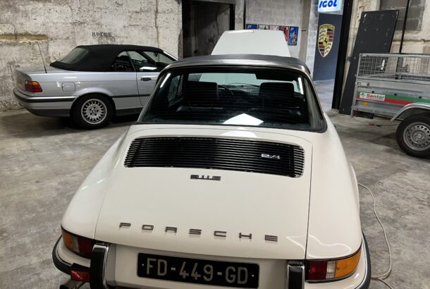 Porsche traga vu de dos dans garage avec bmw en fond
